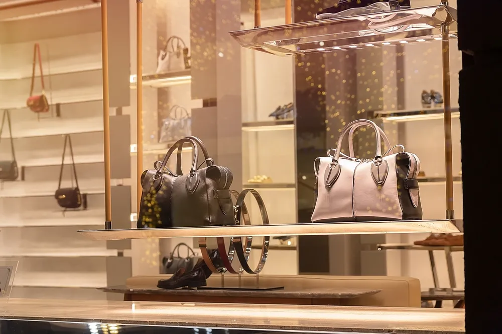 Luxury handbags displayed in a store window, showcasing high-end fashion accessories.